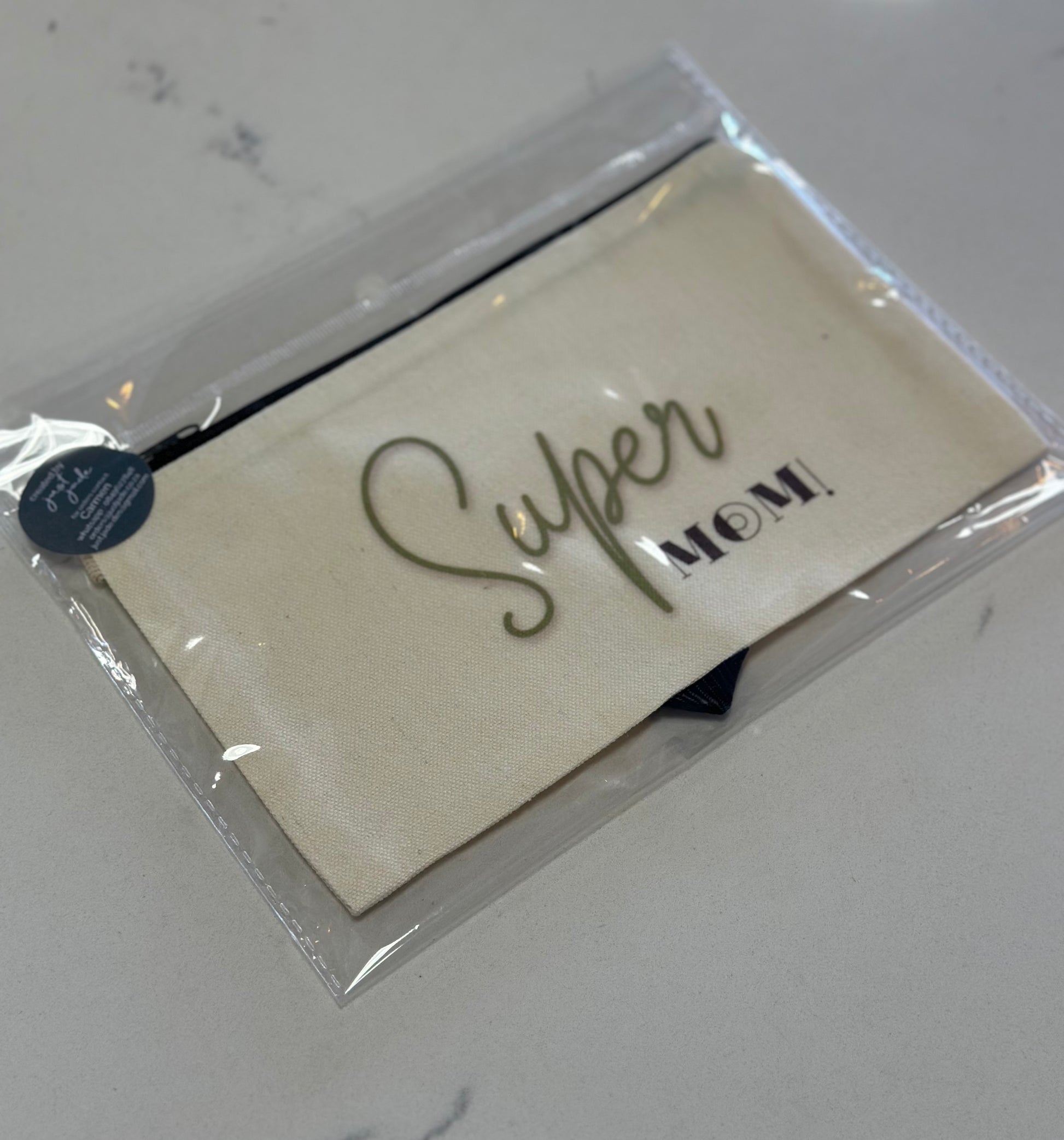 Packaged card with 'Super Mom!' text on a white surface